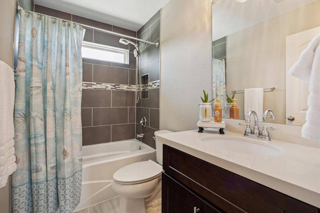 The hall bath has a tub/shower combination and tiled walls. It's between the two secondary bedrooms and is easy to access from the kitchen and living room.