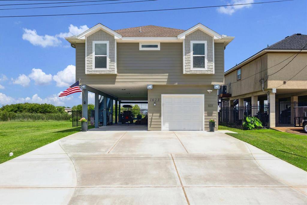 Let's take a closer look at your new home that features a triple-wide driveway and parking for 10 cars. You get easy-to-maintain Hardiplank siding and there's a one-car garage with a workshop behind it. There's a gate that closes off the carport area by the stairs.