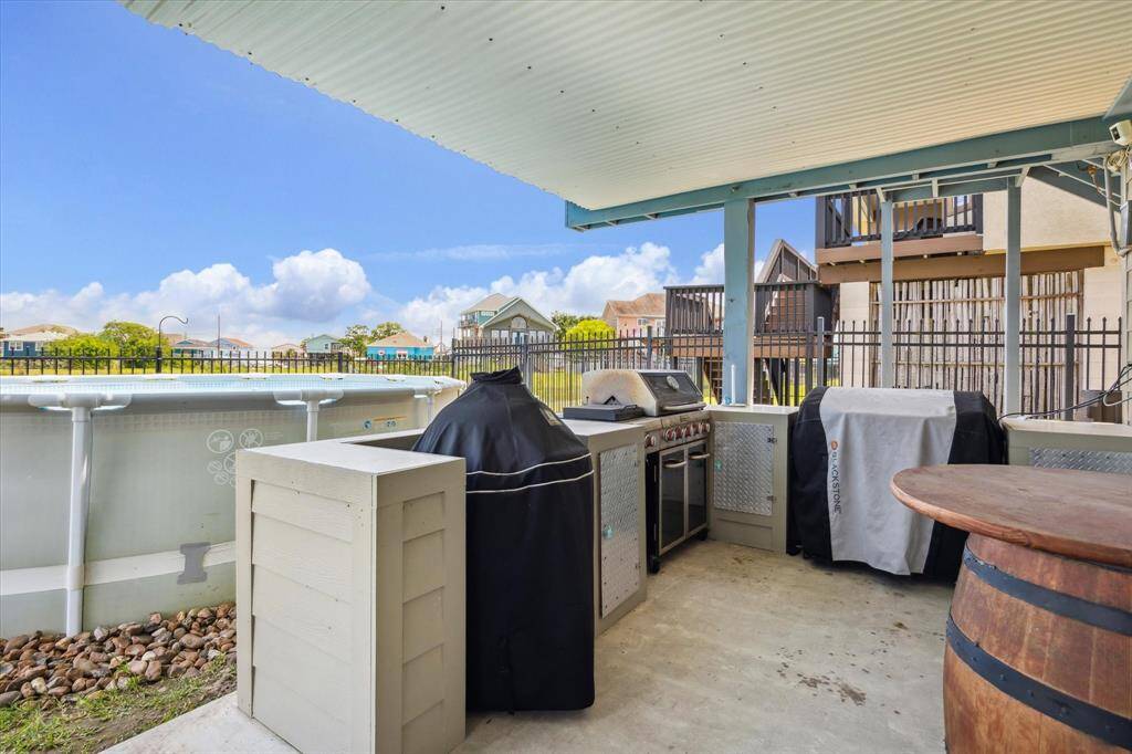 This home features a custom outdoor kitchen the other units don't have The grill can stay but the covered smoker and Blackstone will go. There are cameras and speakers. Check out the ceiling here. It has been upgraded so you have a covered patio downstairs and rain won't leak between your deck boards. It's so nice!