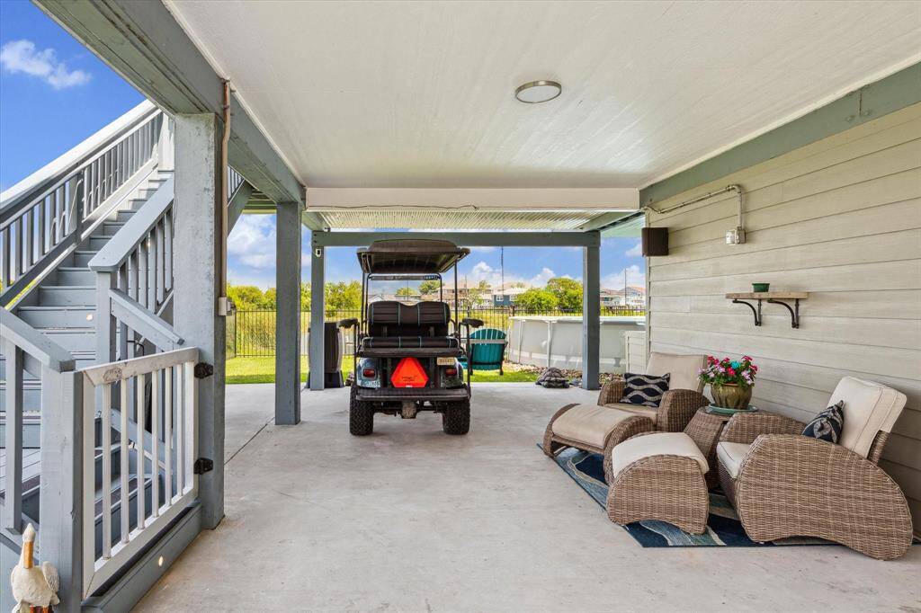We have just come in through the wrought iron double gate, which means you could park a car, truck or trailer where the golf cart is sitting. The stairs lead to the house and there's a garage side door and the workshop to our right. The outdoor kitchen is just around the corner by the pool.