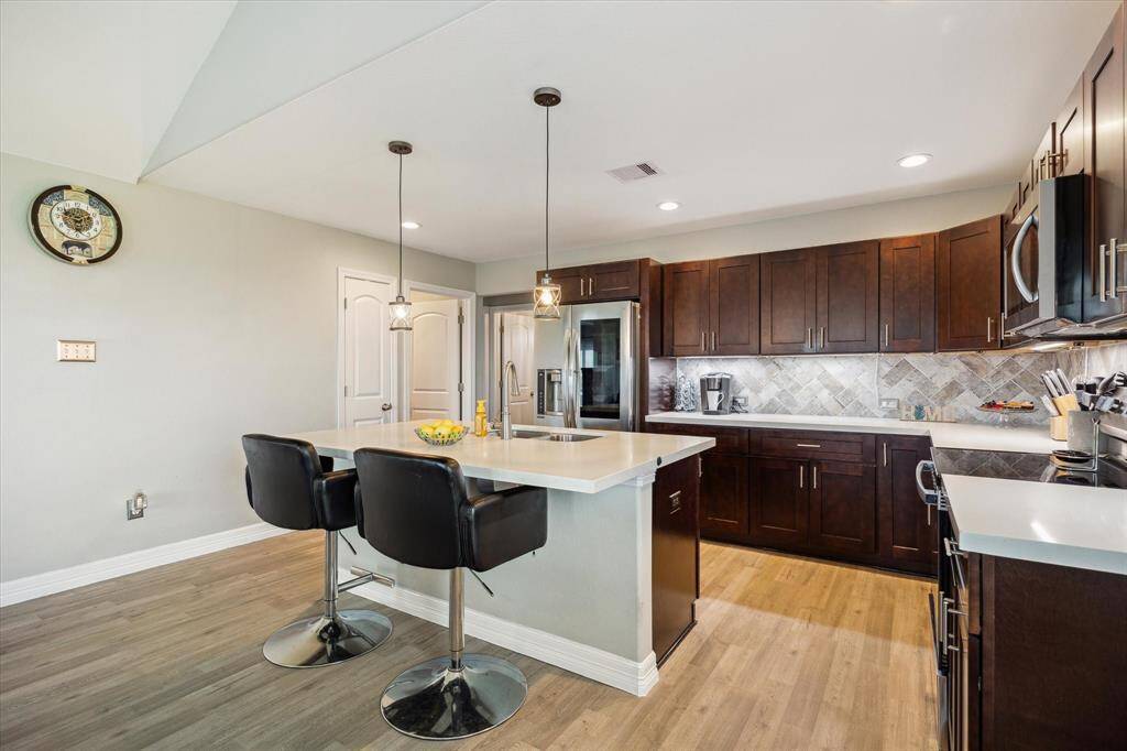 You have an eat-in kitchen with the breakfast bar, dining area shown. The closed door is a pantry and the open door is your utility room. The baseboards are taller and the lights are LEDs.
