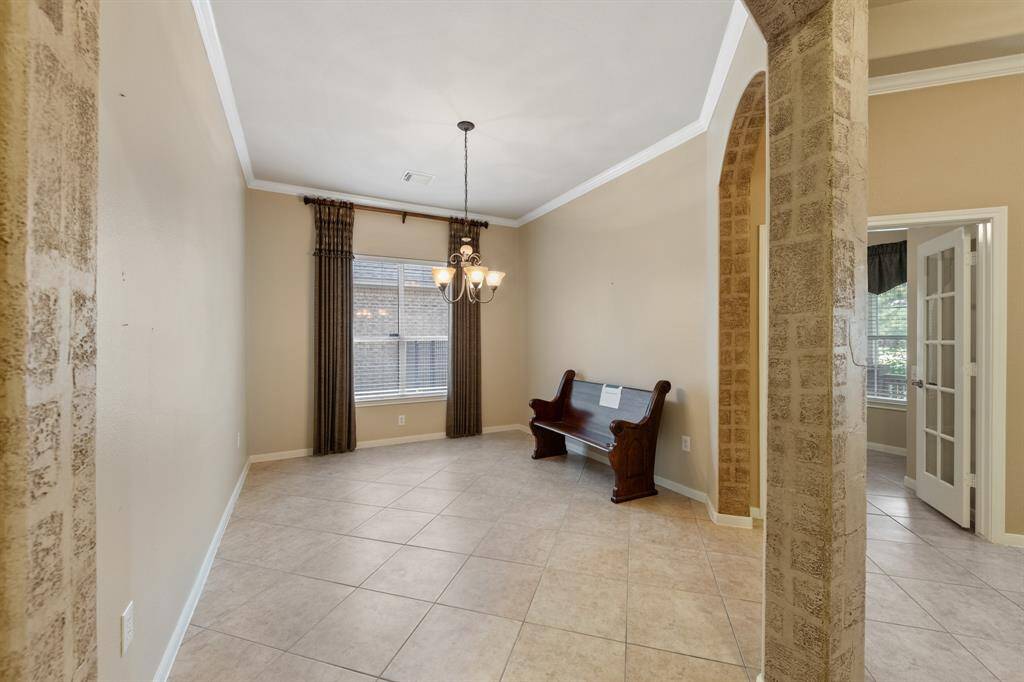 Next to the study is the formal dining room, enhanced with crown molding and an elegant uplight chandelier. Ideal for hosting gatherings and special occasions in an cozy setting.