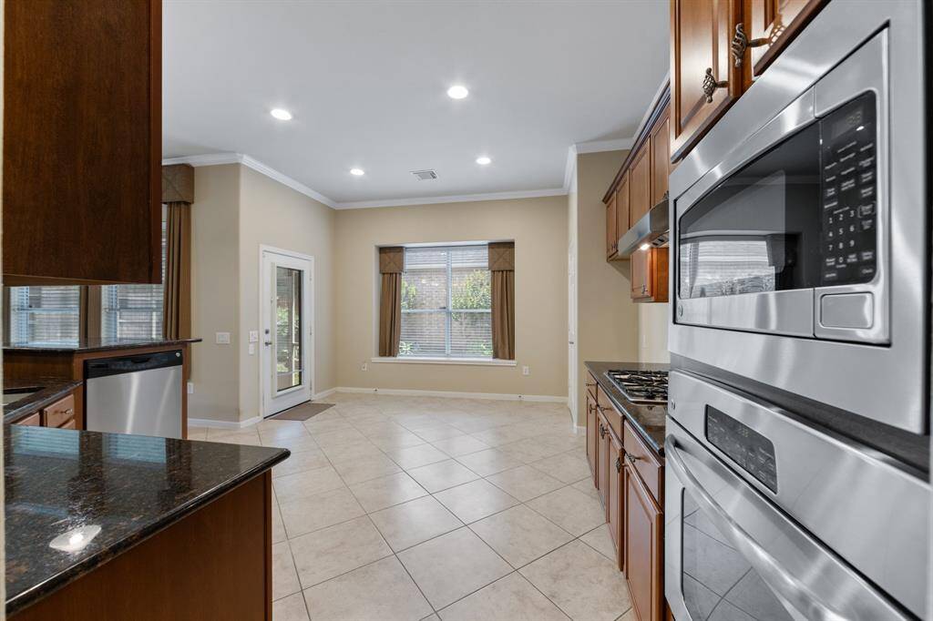 The kitchen features a built-in single oven and microwave combo, seamlessly integrated for convenience and modern culinary experiences.
