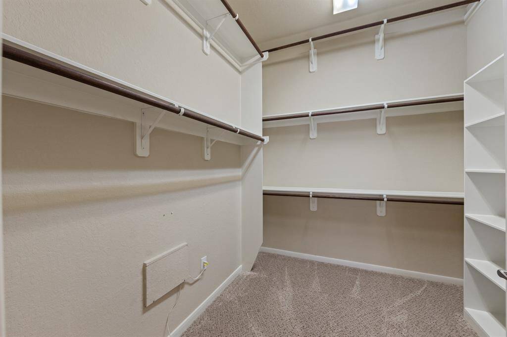 The walk-in closet offers plenty of space and built-in shelves.