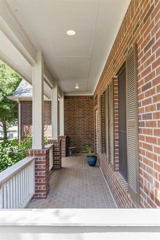 The large front porch spans the width of the home, offering plenty of room for outdoor seating, decor, or a cozy swing. It's a perfect space to unwind while enjoying views of the quiet, tree-lined street outside.