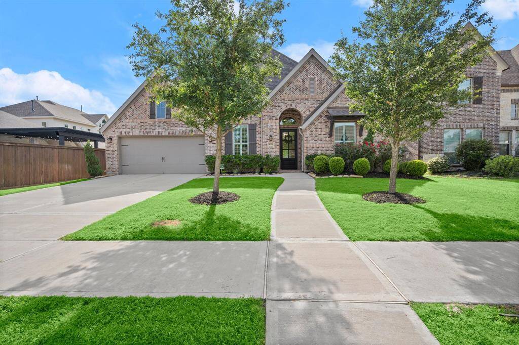 Charming brick home with a spacious three-car garage featuring organizing systems. Enjoy a lush lawn, mature trees, and a welcoming entryway, ideal for families seeking a suburban retreat.