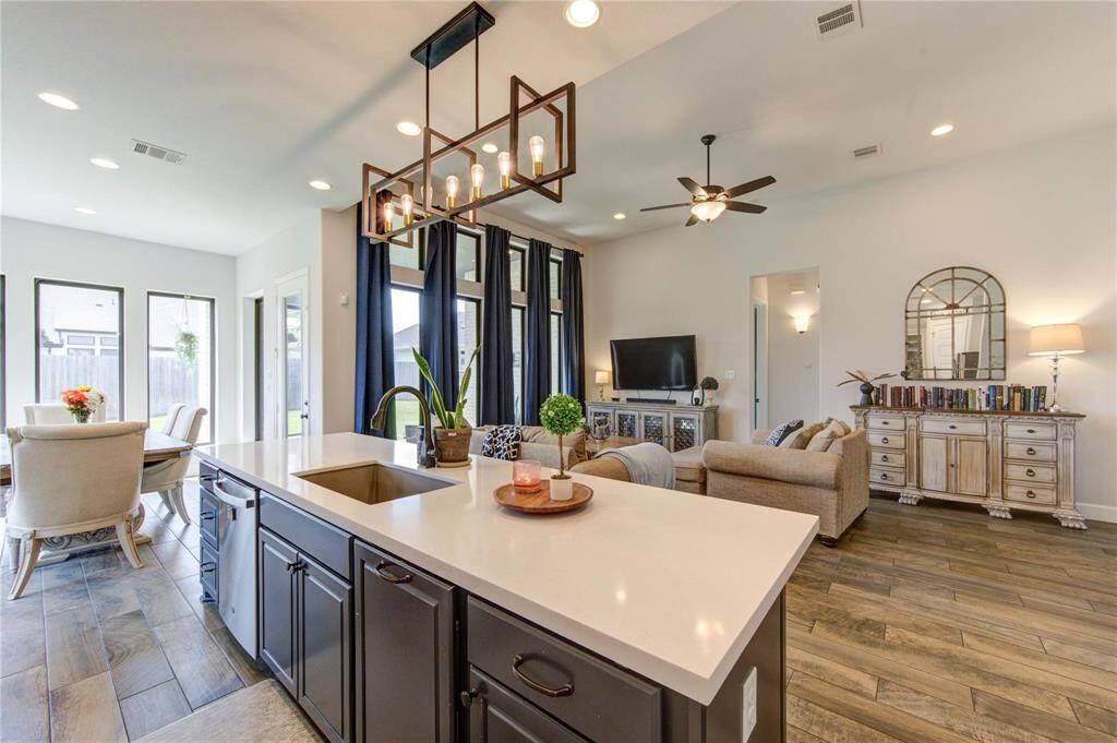 This open-concept living space features a functional kitchen overlooking the living area with natural light from the large windows. The oversized dining/breakfast area is bright and offers views of the backyard.