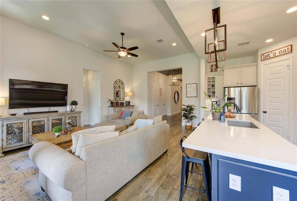 This inviting open-concept area is well-lit with natural light and has a stylish, contemporary design.