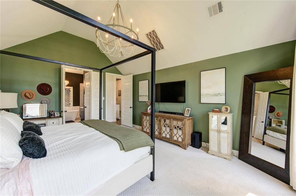 Another view of the primary suite with a chandelier centerpiece