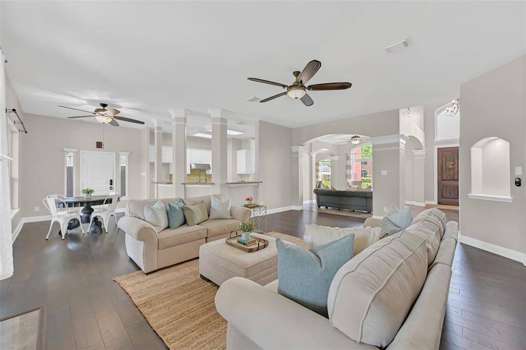 Open-concept living at its finest—this airy layout flows effortlessly from the family room to the breakfast area, kitchen, and formal spaces, all connected by elegant columns and archways.