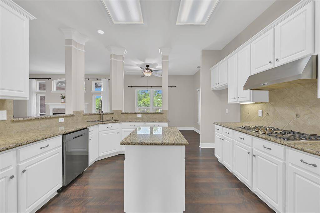 Enjoy open sightlines from this bright kitchen featuring granite counters, gas cooktop, under-cabinet lighting, and a center island. The raised breakfast bar offers casual seating while keeping the chef connected to the living spaces.