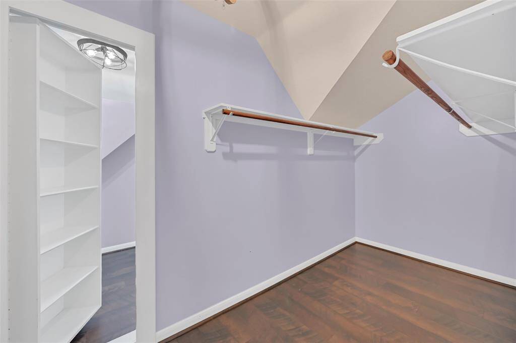 Spacious walk-in closet with built-in shelving and a hidden doorway leading to a bonus storage space—an ideal solution for seasonal items, keepsakes, or creative use of tucked-away square footage.