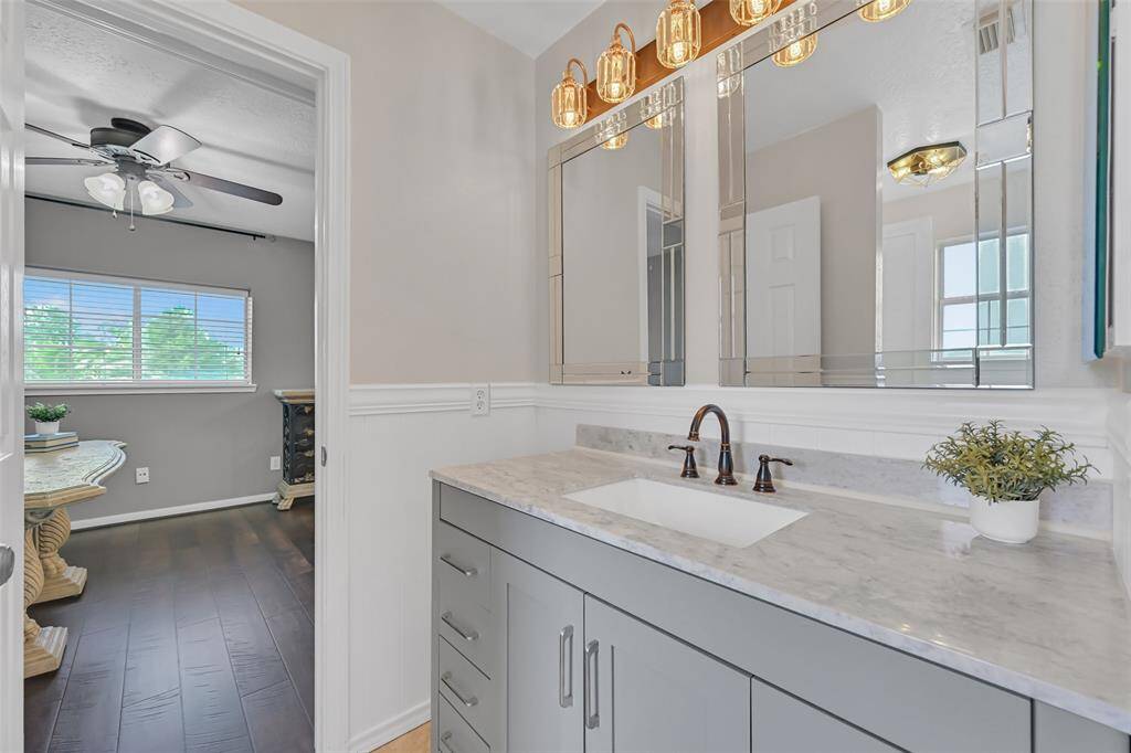 Beautifully updated bathroom with marble-look quartz counters, a rectangular basin sink, framed mirrors, oil-rubbed bronze fixtures, and a shower/tub combo. Conveniently accessible from both a secondary bedroom and a versatile bonus study off the game room.