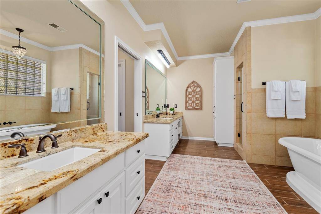 The primary bath features double vanities, a soaking tub, large separate shower, and two walk-in closets—offering the best of luxury and functionality.  You will feel like you just walked into to your own personal spa retreat!