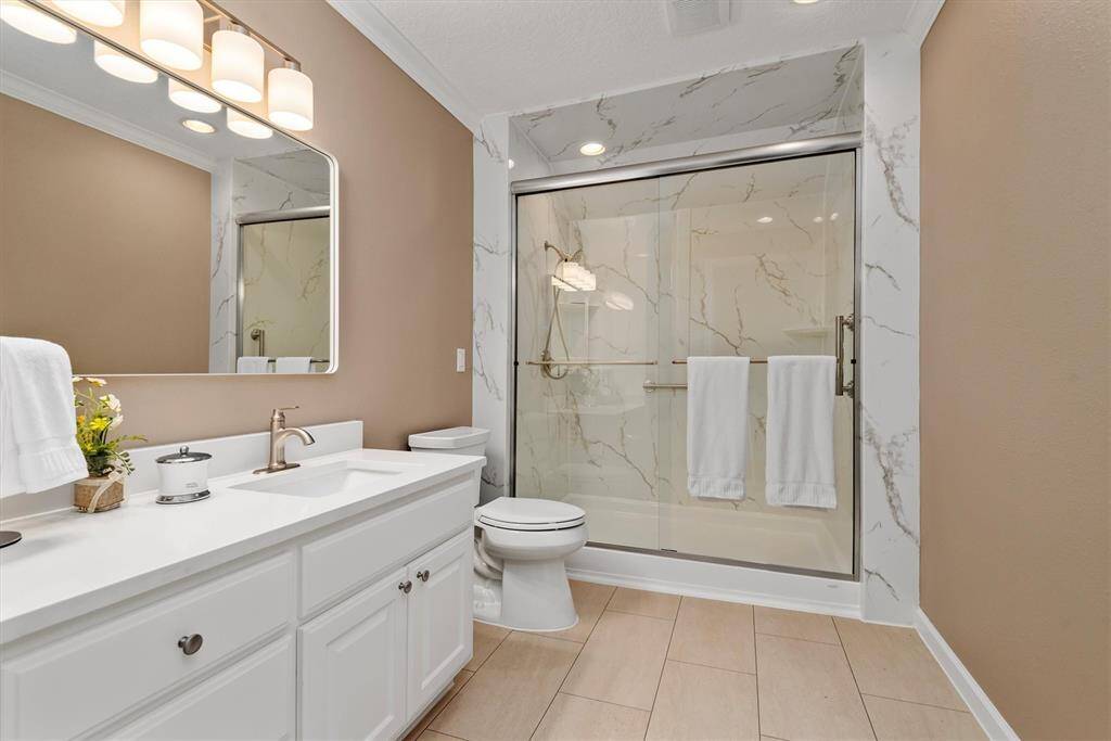 Upstairs Bathroom 1 - Fully Remodeled in 2024 - Full guest bathroom featuring a large vanity with plenty of storage, modern lighting, and a spacious walk-in shower with sliding glass doors.