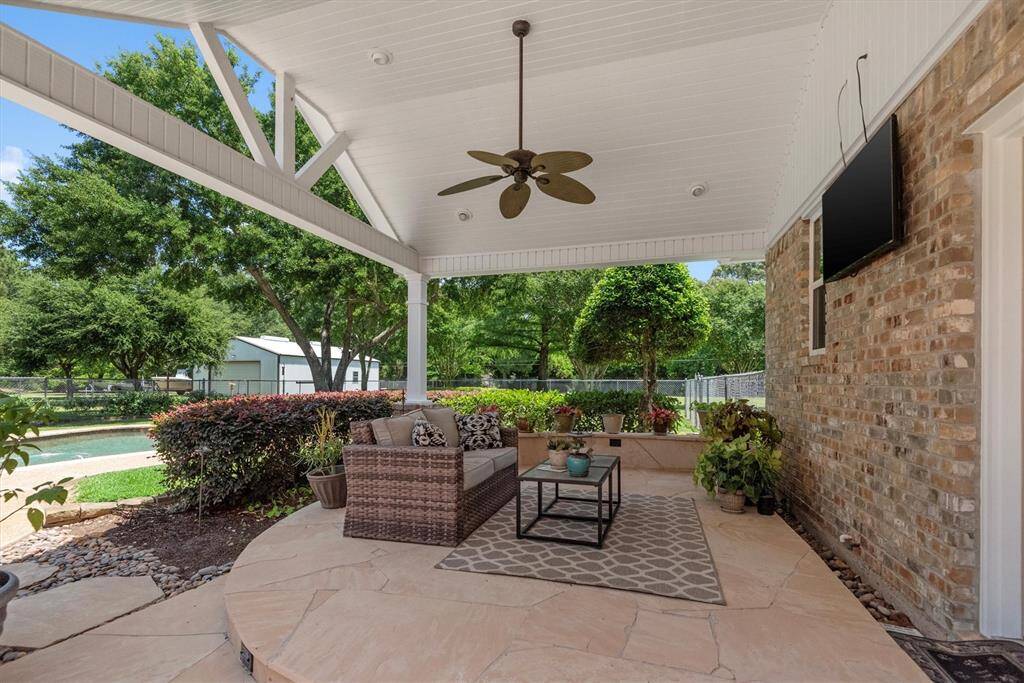 This extended covered patio with ceiling fan, TV mount (TV excluded), and plenty of seating space is perfect for watching the game, hosting gatherings, or enjoying quiet evenings outdoors. This patio is located right off the detached garage.
