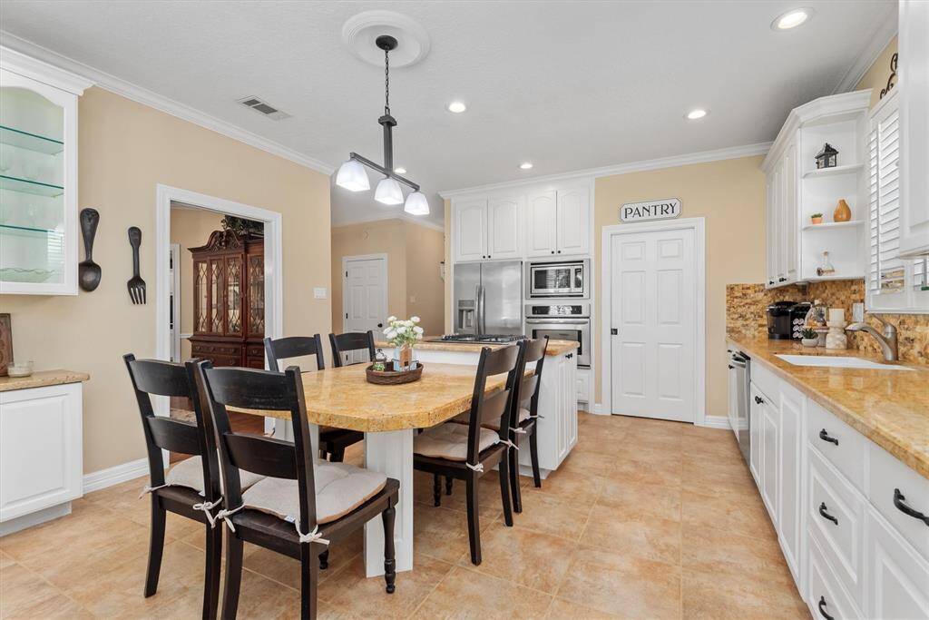 Take a look at this light and bright kitchen with granite counters, gas cooktop, electric oven, and a large island—perfect for casual meals and entertaining.