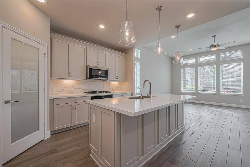 Discover modern elegance in this bright, open-concept kitchen and living area. Modern cabinetry, a stylish island with pendant lighting, and large windows for natural light, this space is perfect for entertaining and everyday living.