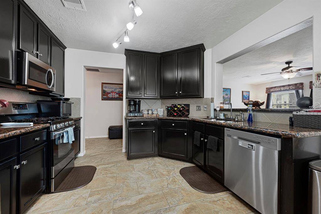This kitchen boasts sleek stainless steel appliances, including a refrigerator with an ice maker.