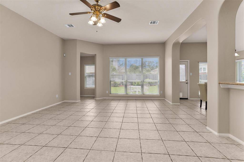 Family room features gas log fireplace, ceiling fan and art niche