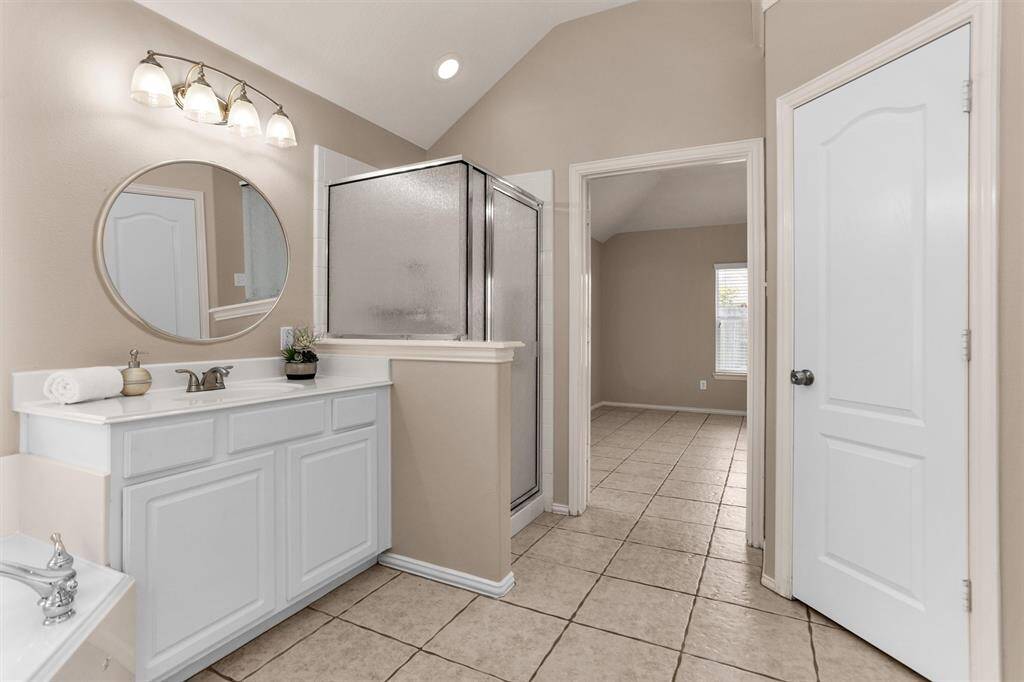 Primary bath features separate vanities, upgraded fixtures, stand alone shower
