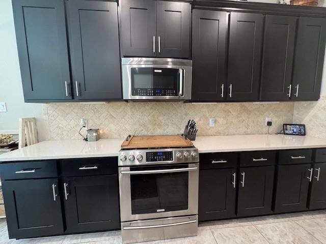 Tall cabinetry and stainless appliances.