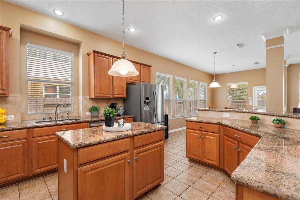 The kitchen is designed for both everyday living and entertaining, featuring a center island and a large breakfast bar that wraps around.  There's ample seating for everyone.