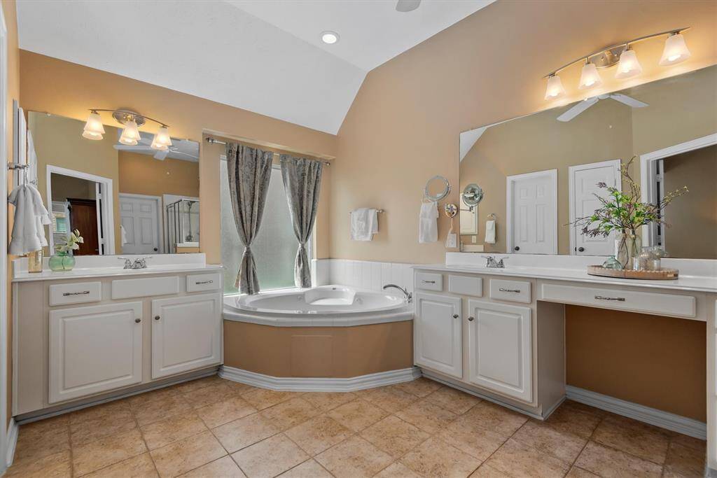 The primary bathroom features a relaxing jetted tub, dual vanities, a separate walk in shower and a spacious closet.