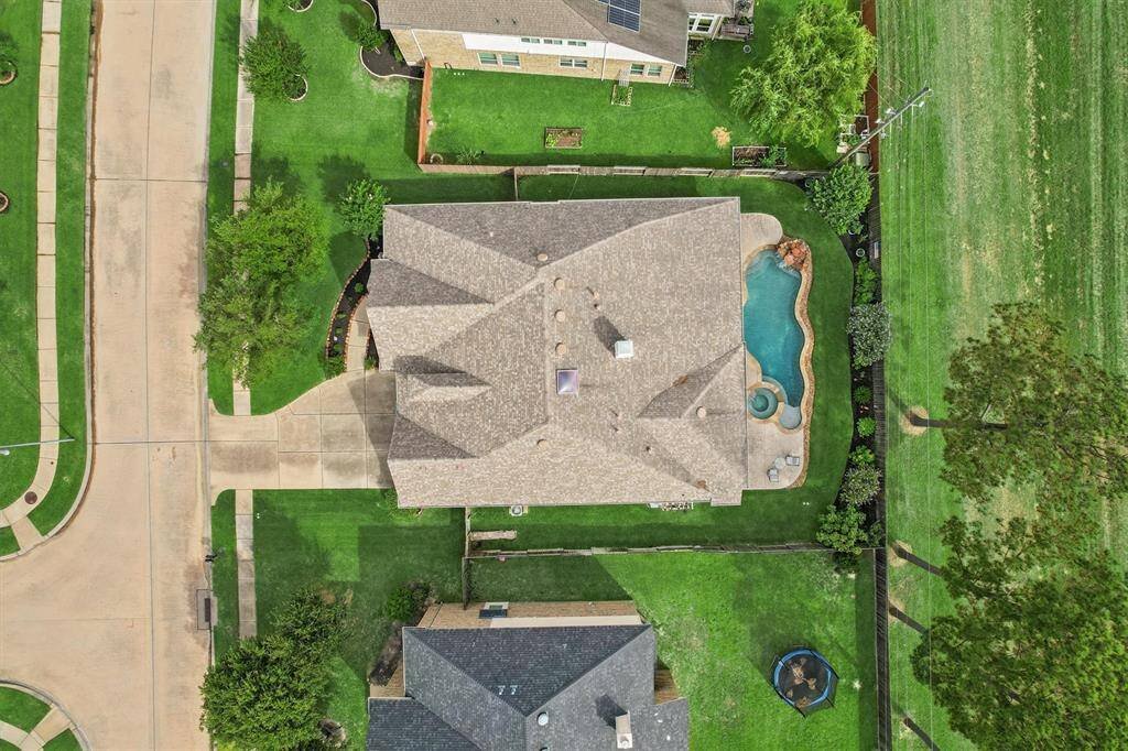 The aerial view reveals it all- a stunning backyard oasis with a sparkling pool, lush landscaping and no rear neighbors.