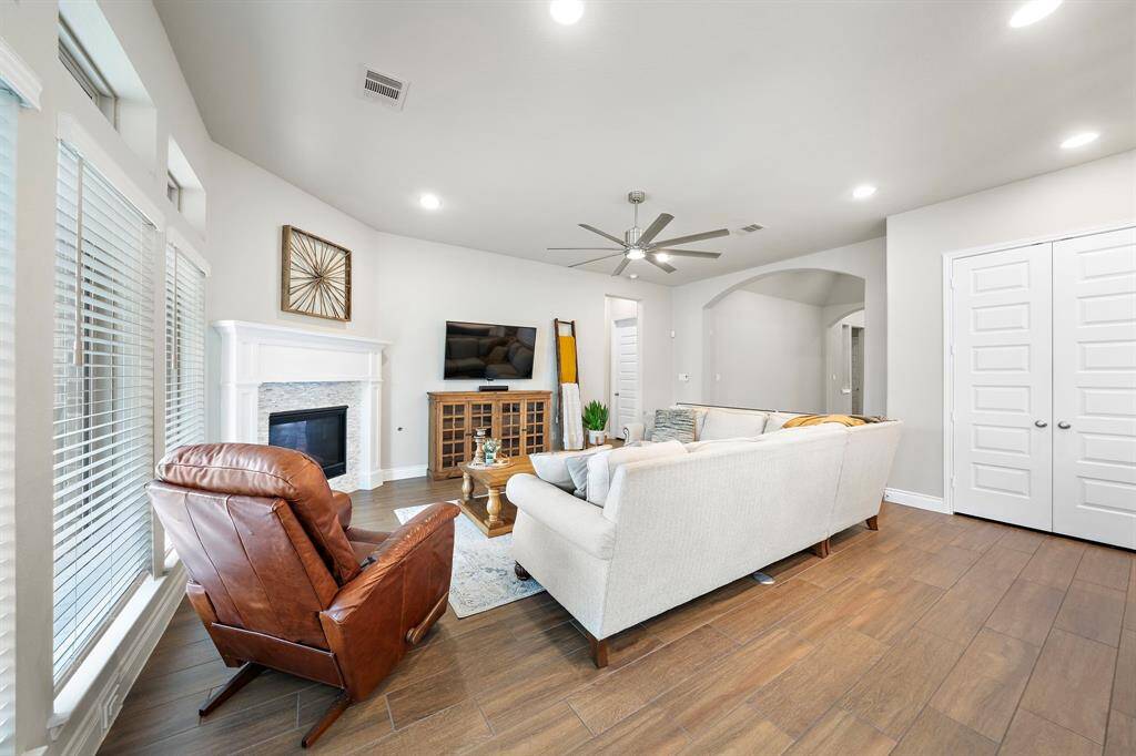 Gather in the inviting family room with a wall of windows and a cozy wood mantel fireplace.