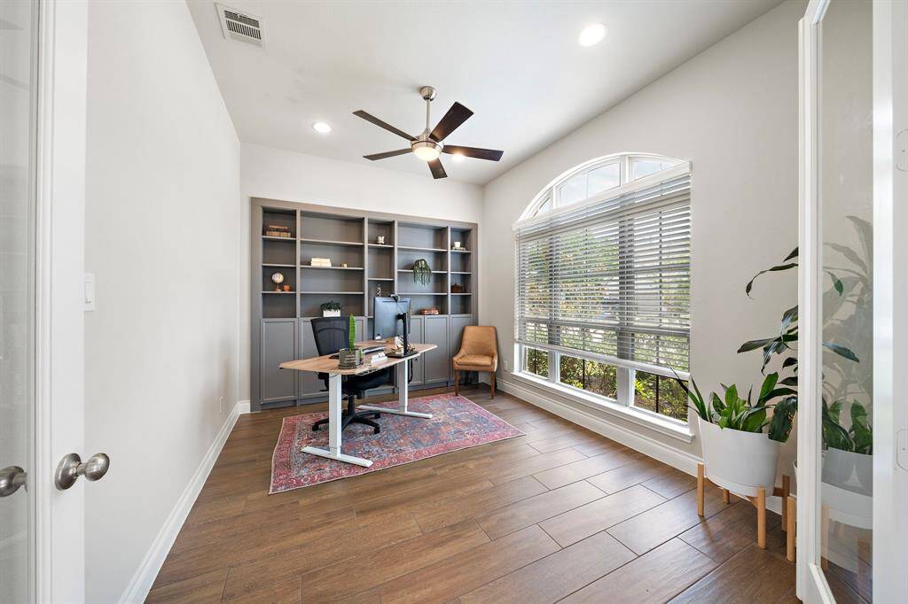 Tucked at the front of the home, the office boasts French doors and wood-look ceramic tile.