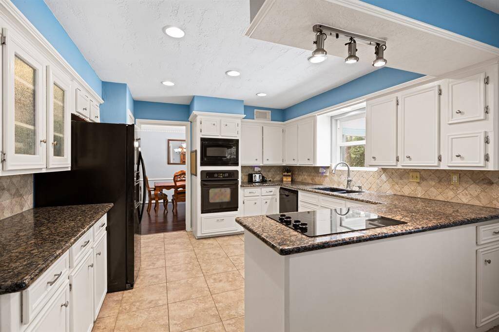 KITCHEN - Granite countertops and tile backsplash.
