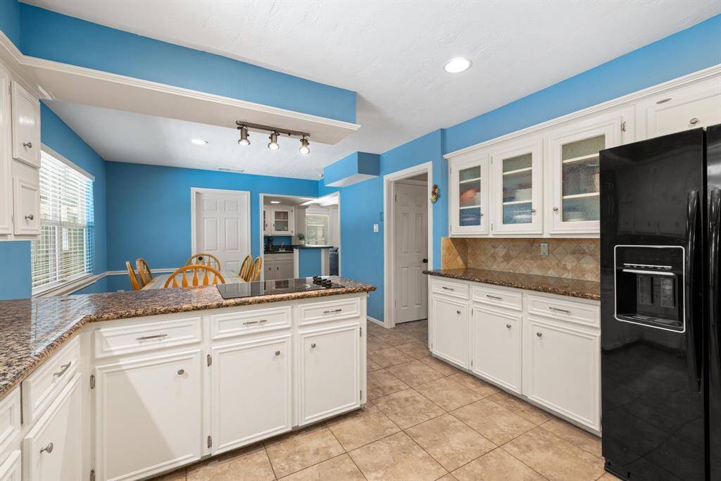 KITCHEN - Lots of counter space.  Cabinets with glass fronts for displaying those special dishes.  Refrigerator will remain with home.