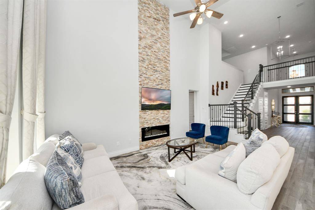 A ceiling fan adds comfort and functionality, while the  stylish fireplace serves as a beautiful focal point in the room.