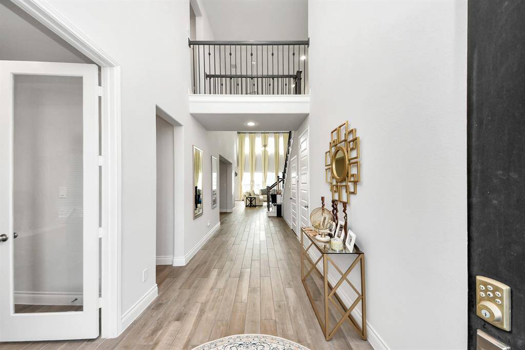 The high ceilings, light colored wood-like tile, and natural like make this foyer feel massive. Don't forget to glance up at the chandelier!