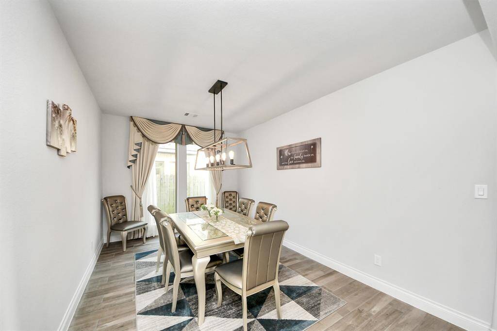 The dining room offers ample space to comfortably accommodate an 8-person table, whether round or rectangular.