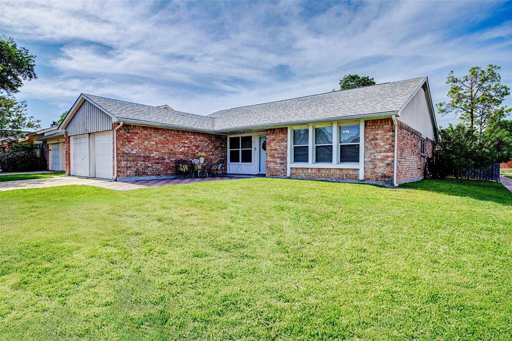 This is a charming single-story brick home featuring a large, well-maintained front lawn. It includes a two-car garage, a cozy front patio area, and a welcoming facade with ample windows for natural light.