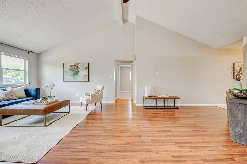 This photo showcases a spacious, open living area with high ceilings and abundant natural light.