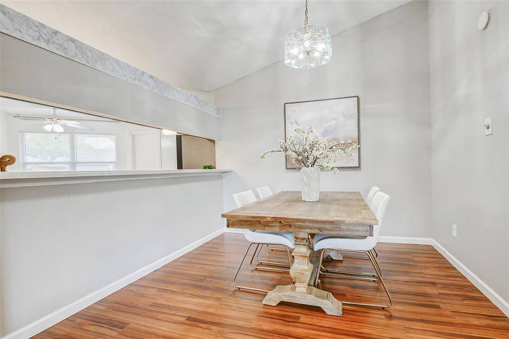 Bright dining area with modern chandelier, laminate flooring, and an open layout. The perfect spot for dining or entertaining.