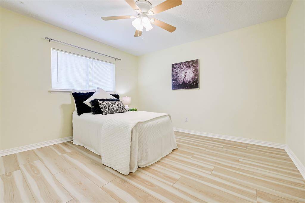This secondary bedroom is located to the right of the living area on the opposite side of the house from the primary bedroom. A large window provides natural light into the room.