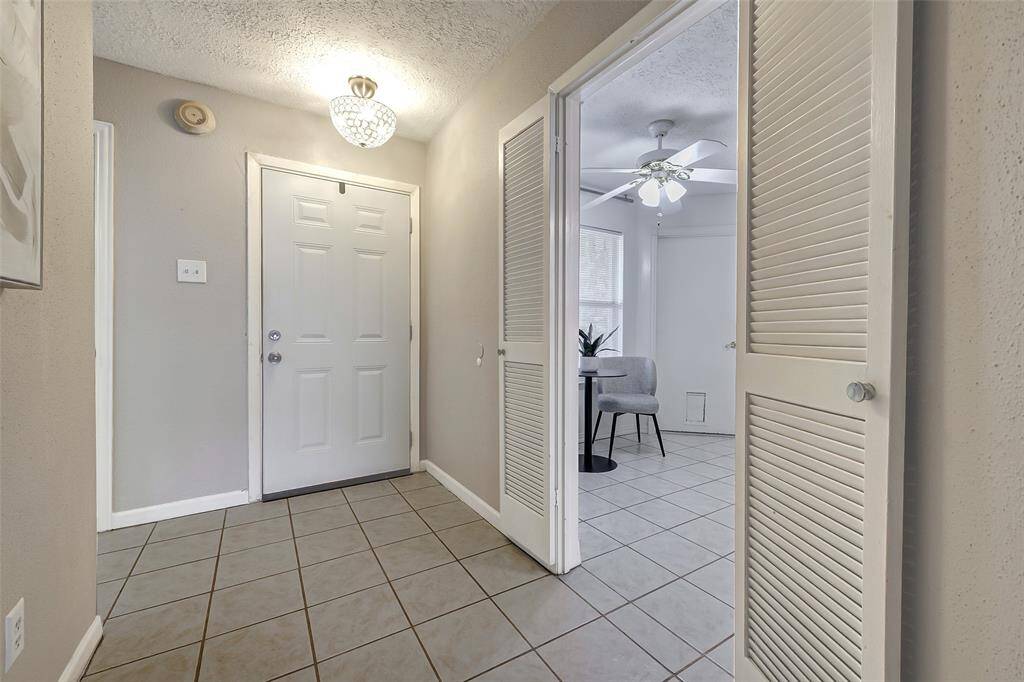 Looking back towards the front door. The kitchen is to the left of the front door and a bedroom is to the right.