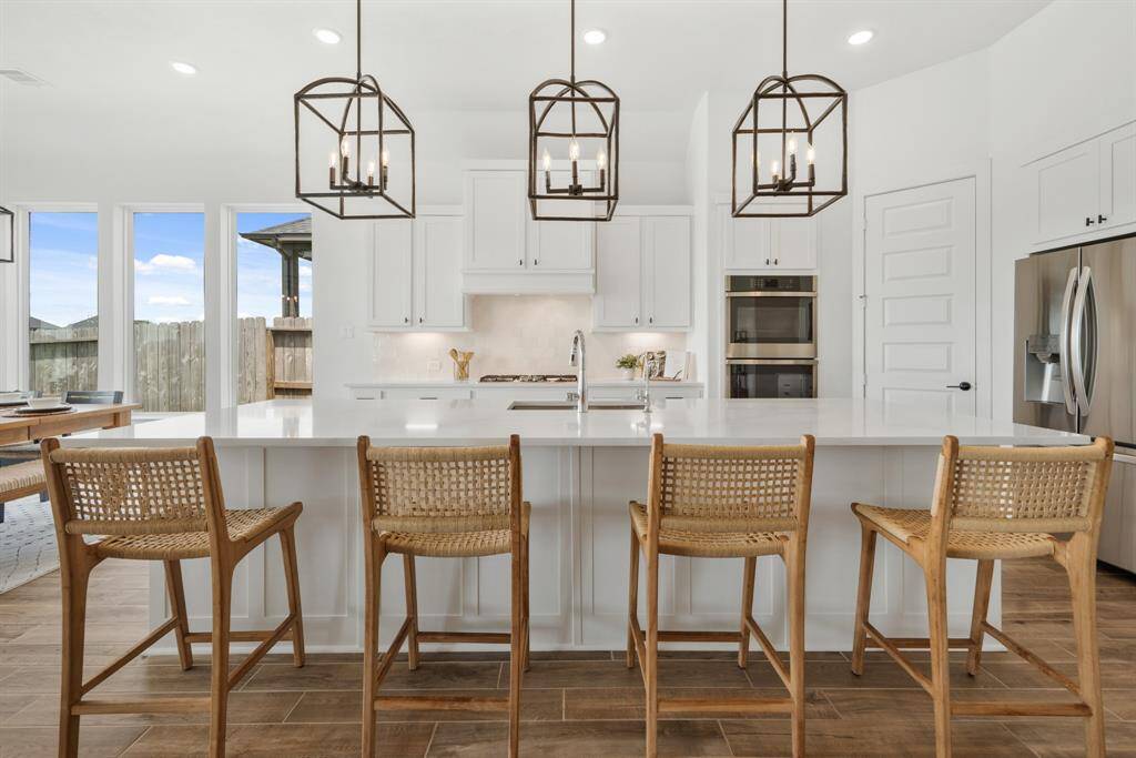 The generous breakfast bar provides extra seating, making it the perfect spot for casual meals or morning coffee. The countertops showcase elegant Silestone Quartz in Eternal Calacatta Gold, blending beauty with durability for everyday living.