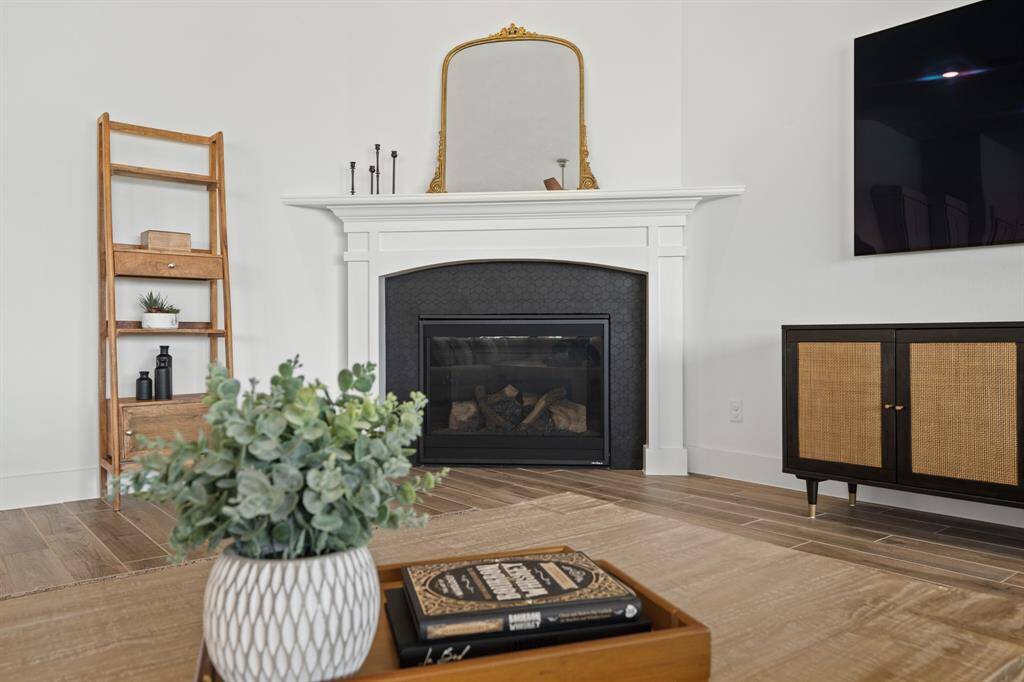 The fireplace is a stunning focal point, featuring a decorative Sublimity Daphne Mosaic tile surround and a beautifully crafted wooden mantel, blending classic charm with contemporary elegance.