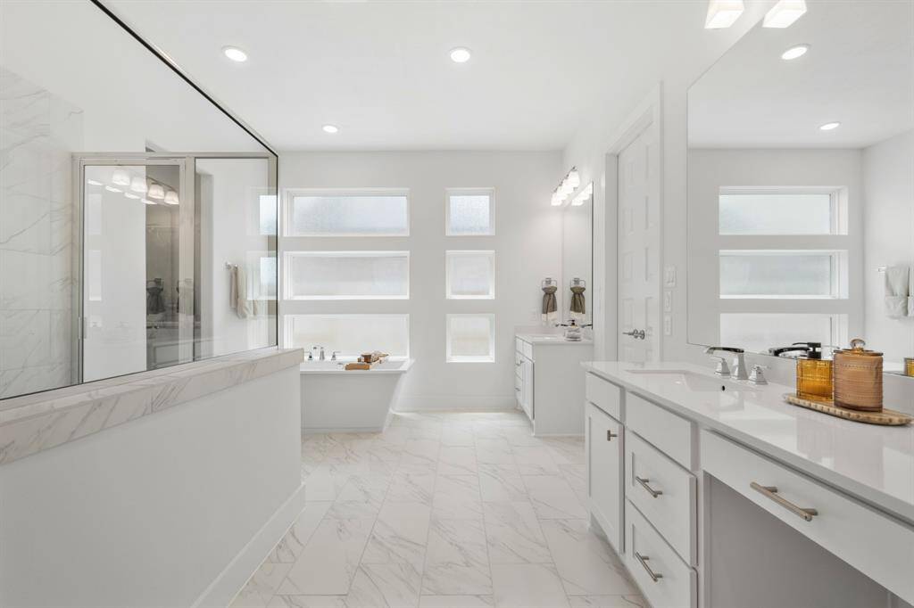 Step into your luxurious, spa-inspired ensuite, where sleek tile flooring flows seamlessly throughout. Painted JKraft cabinetry in Studemont Pure White pairs beautifully with Silestone Quartz countertops in Et Statuario, while thoughtfully selected designer finishes complete the look—creating a serene retreat ideal for daily indulgence and rejuvenation.