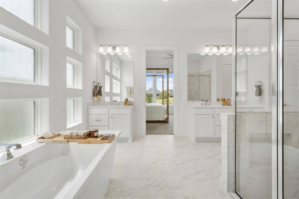 The Freestanding Optik model tub is perfectly positioned beneath multiple obscure rain-glass windows, allowing natural light to pour in while maintaining a sense of privacy—creating the ultimate setting for a peaceful soak.