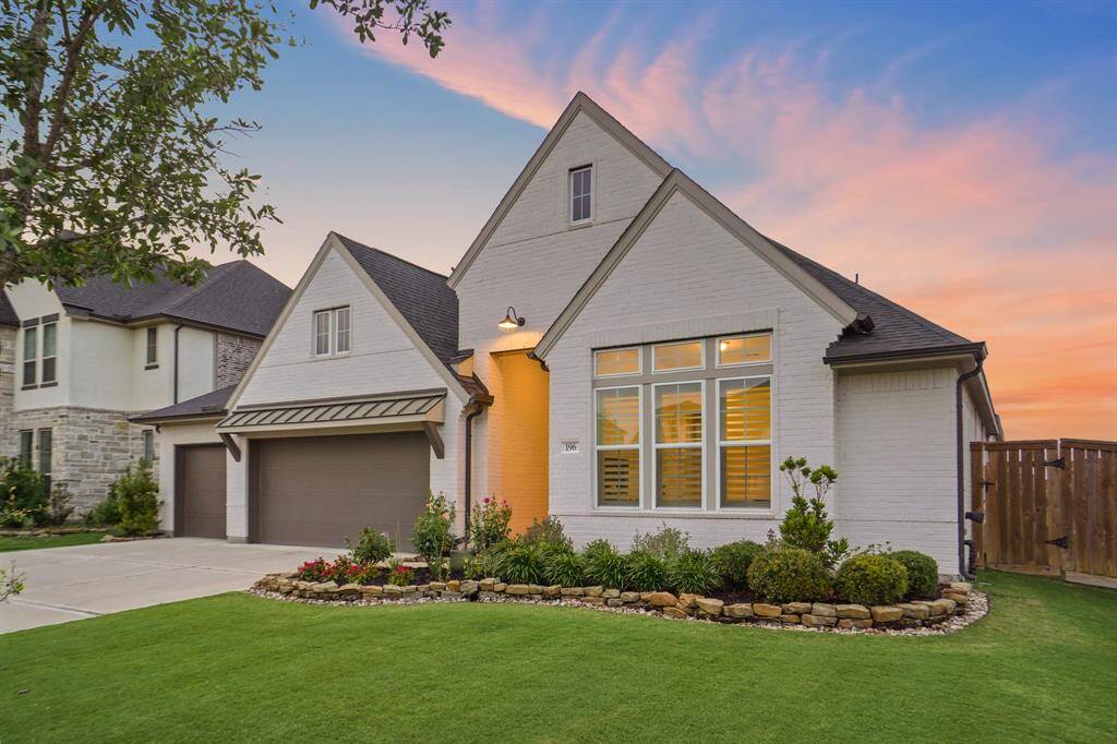 This brick home showcases a pitched roofline, three-car garage, and clean architectural lines. Ample driveway space and manicured landscaping accentuate its modern design.
