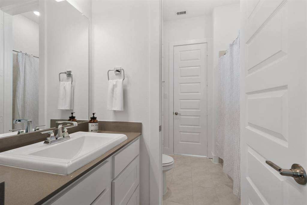 The tub/shower combo is beautifully accented with Cabris Fair tile installed in a 1/3 offset pattern, complemented by a running bond tile design throughout the secondary baths—adding timeless style and subtle texture.