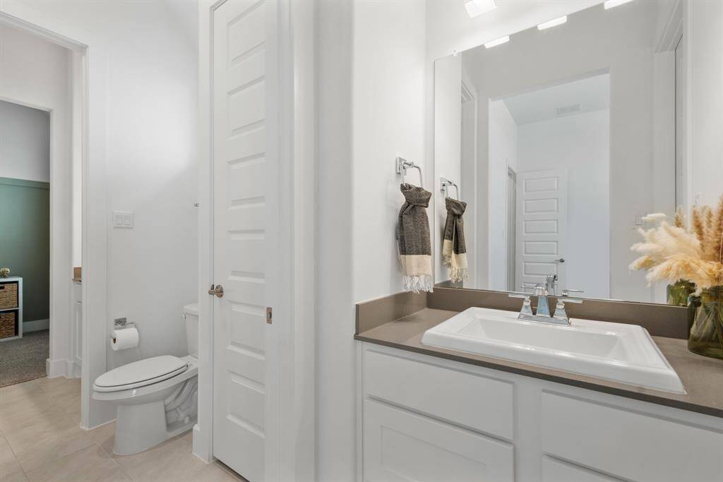 Each guest bedroom boasts its own private vanity featuring painted JKraft cabinetry in a crisp Studemont Pure White finish, paired with elegant Grey Expo Quartz countertops finished with a clean square edge—combining style and functionality in every space.