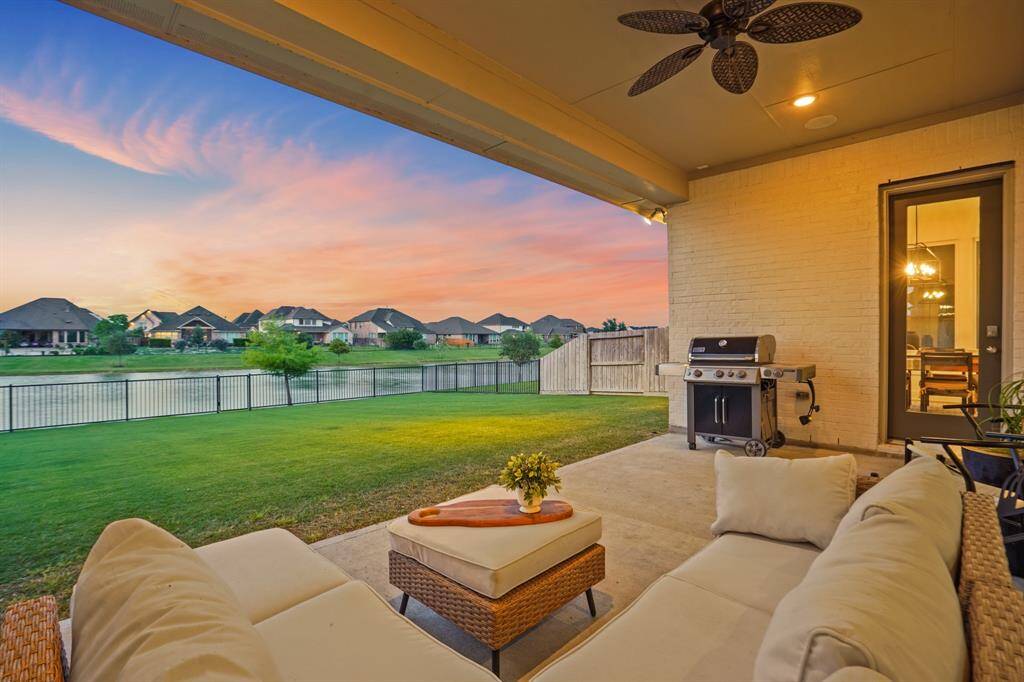 A wide backyard with water views provides privacy and open space, ideal for relaxation or play. The covered patio connects seamlessly to the home’s interior for easy indoor-outdoor flow.