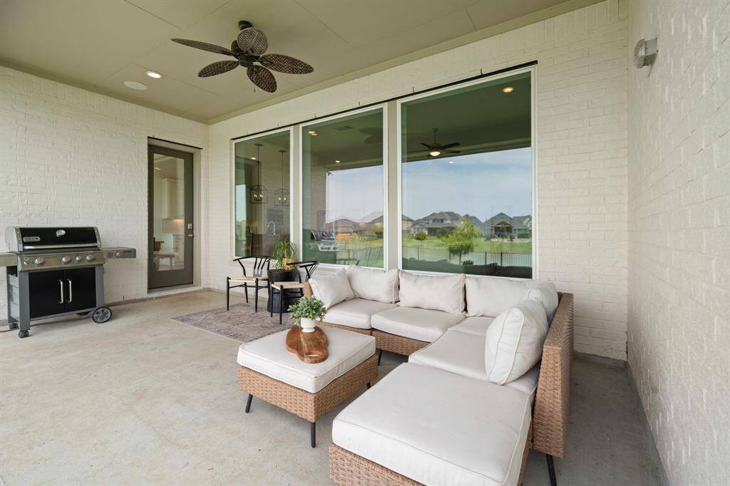 Step outside to discover a spectacular retreat under the massive covered patio, offering ample space for your outdoor furniture. A ceiling fan overhead ensures refreshing air circulation, creating the perfect spot to relax and unwind.